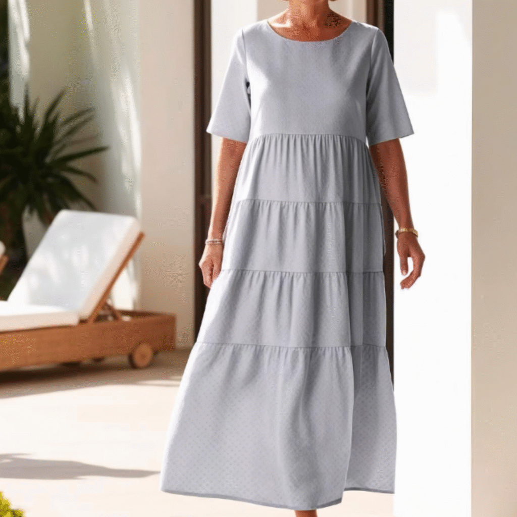 Woman wearing a light blue tiered maxi dress with elbow-length sleeves and a round neckline. The loose, flowy fit gives a breezy, modest look perfect for summer.